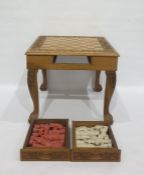 Carved wooden chess table with carved decoration, drawers on either side containing resin chessmen