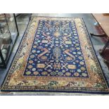 Blue ground rug, the central field with flowerhead and hooked motifs, stepped border, 239cm x 155cm