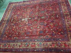 Red ground rug with allover foliate decoration, stepped border 355 cm x 300 cm