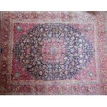 A North East Persian signed Meshad carpet, central double pendant medallion on a midnight field,