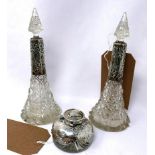 A pair of silver mounted cut glass scent bottles, of tapered form with silver collars embossed
