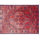 A Turkish rug with geometric floral medallion, on a red ground, contained by geometric border, 200 x