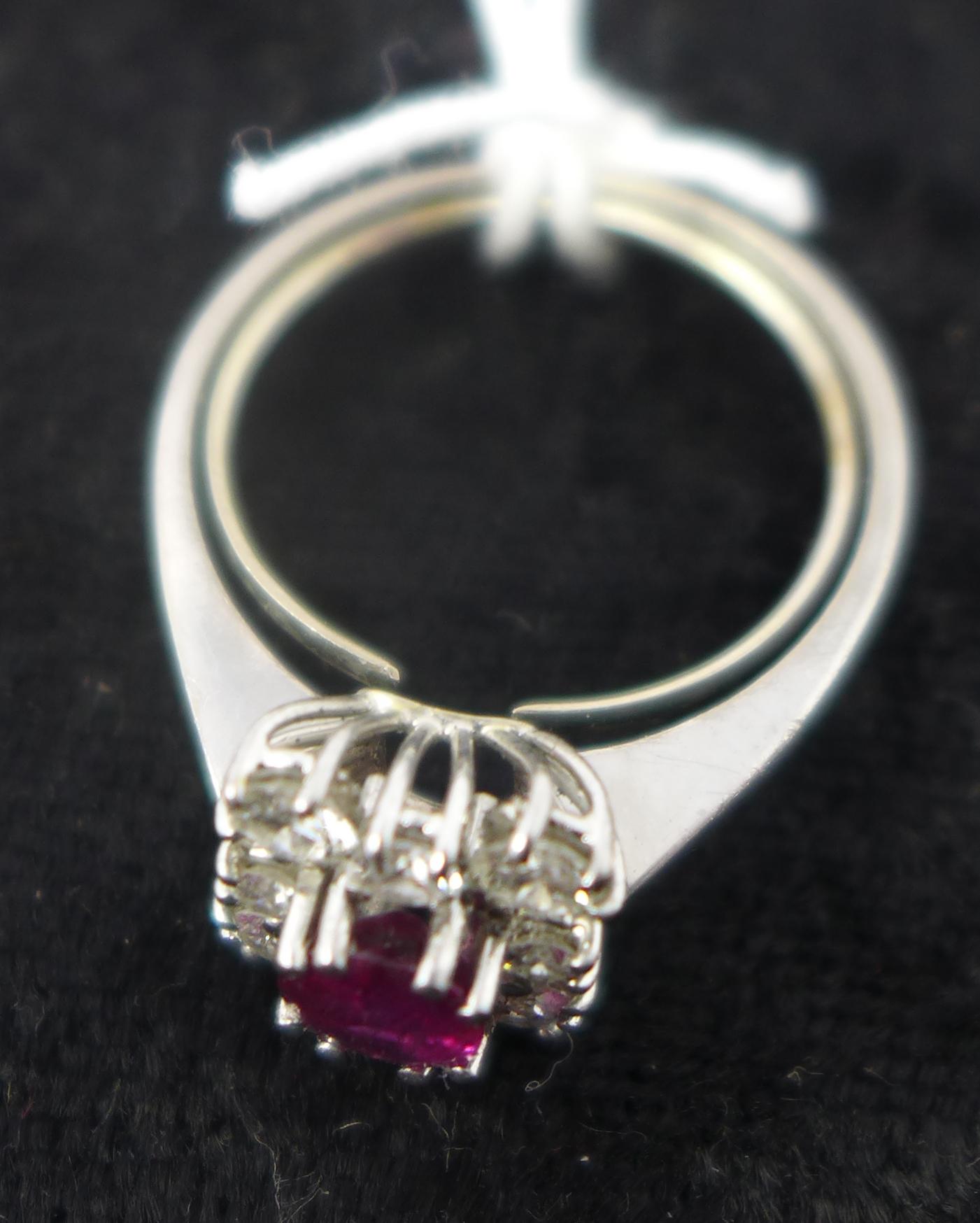 An 18ct white gold, natural ruby and diamond cluster ring, the central oval faceted ruby in a six- - Image 2 of 2