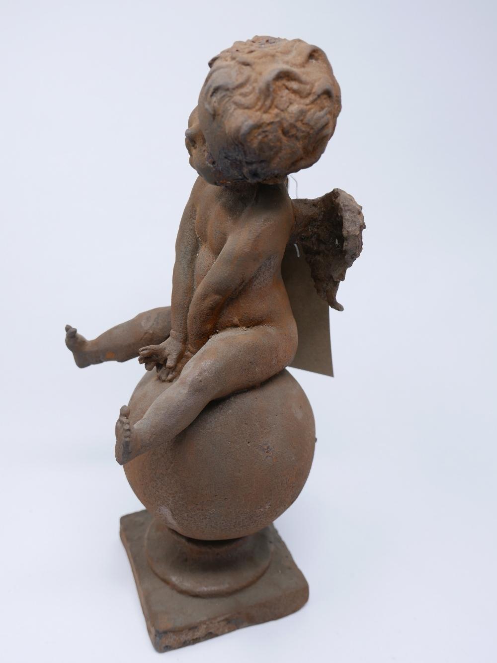 A cast iron cherub sitting on a globe raised on socle base, H.40cm - Bild 2 aus 2