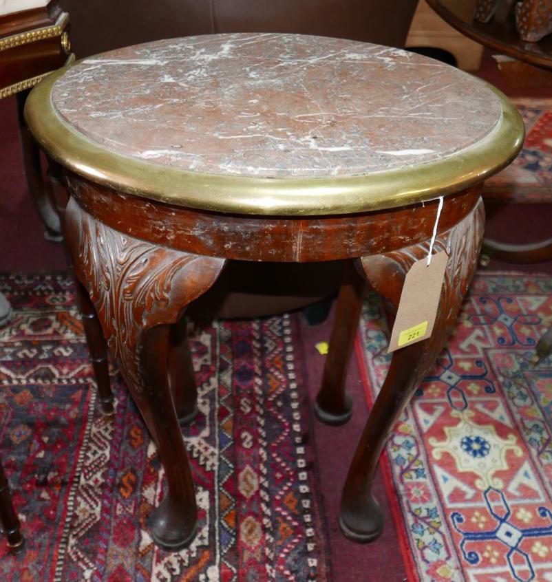 A pair of marble topped oval low tables with brass bound edges on mahogany carved cabriole supports.