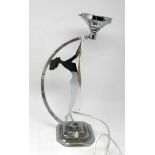 An Art Deco chromed metal table lamp with a stepped square base and featuring the silhouette of an