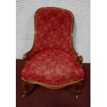 An early 20th century Edwardian walnut framed nursing chair, button red tapestry and front