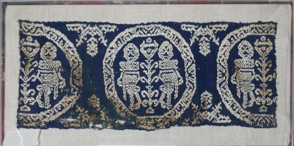 A Middle Eastern textile, framed in a perspex case H.16 W.40cm