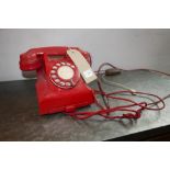 A vintage red Bakelite rotary telephone