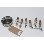 A silver plated bottle coaster and a collection of wine bottle stoppers and pourers