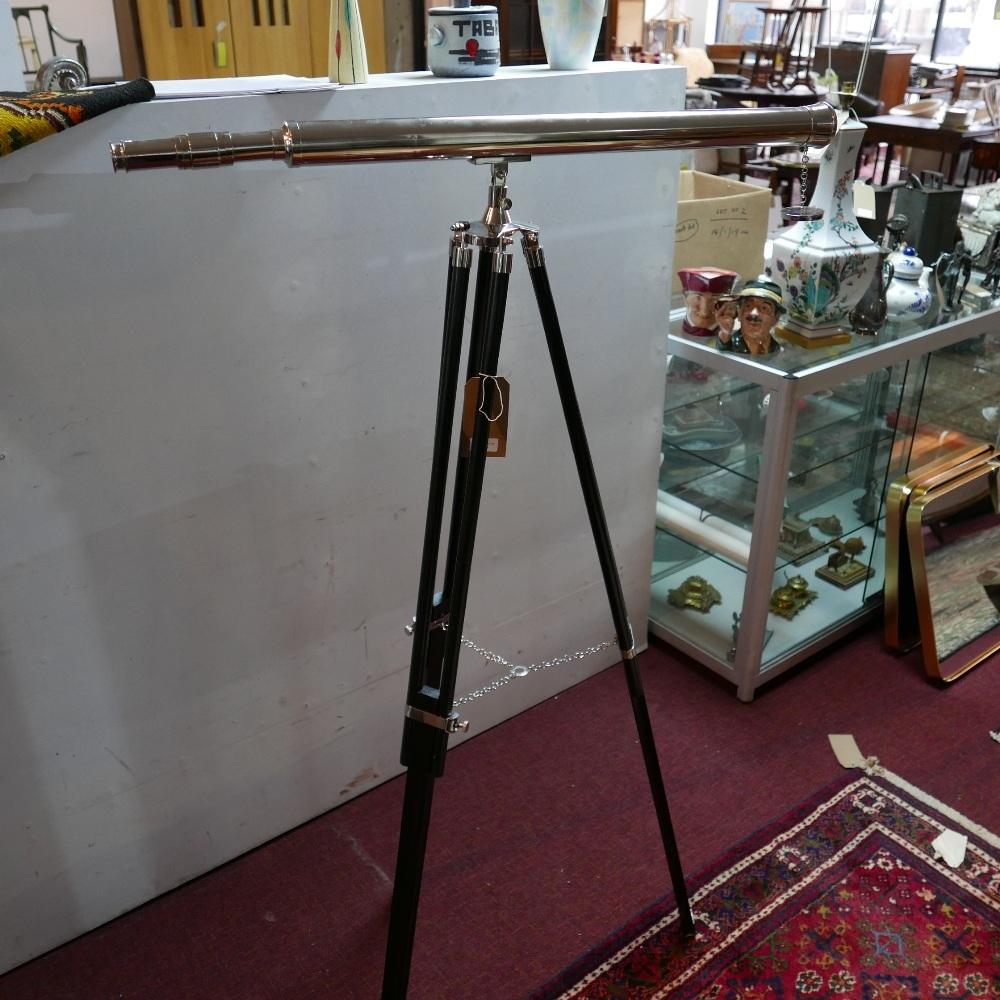 A contemporary telescope, on adjustable tripod stand
