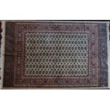 A Bokhara style carpet with elephant pad motifs, on a beige ground contained by geometric border,
