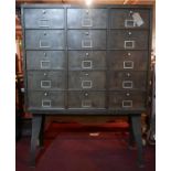 An industrial metal cabinet, with 15 pull down compartments, raised on iron base, H.166 W.122 D.32cm