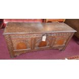 An 18th century oak coffer with three carved panels and fitted candle box, H.63 W.135 D.43cm