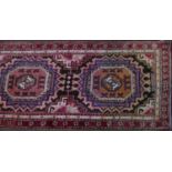 A North West Persian Heriz runner, repeating elephant pad motifs on a midnight field, within