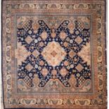A signed Nepalese carpet with geometric floral motifs, on a blue ground, contained by floral