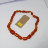 A large, baltic natural amber bead necklacxe composed of twenty-five, graduated beads of polished,