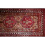 A 20th century Persian runner with five pole geometric medallion, on a red and beige ground,