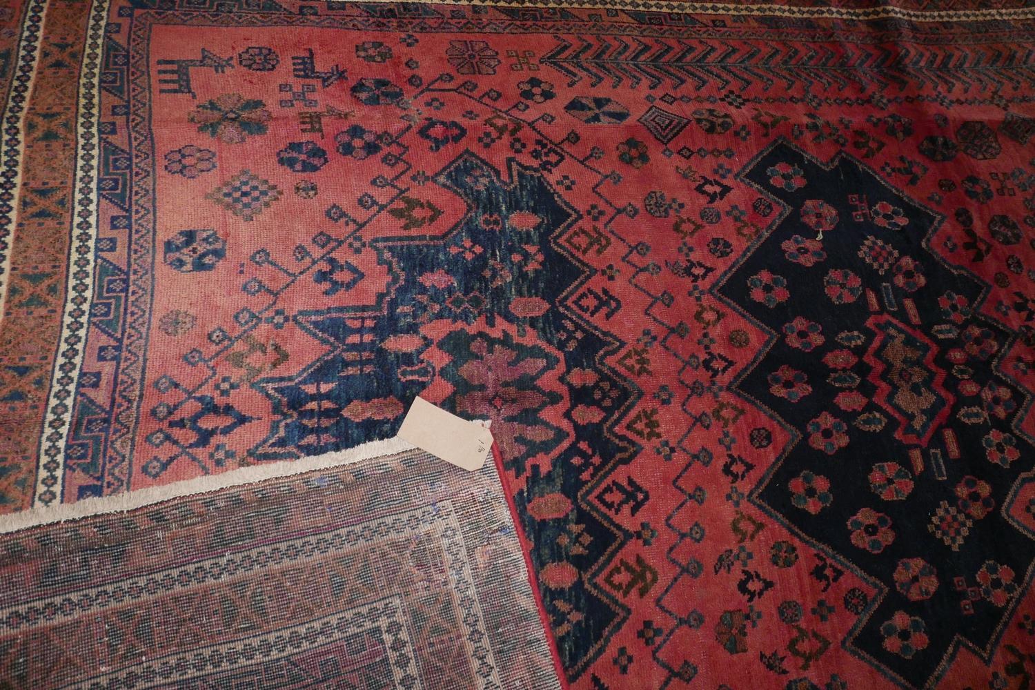 A North West Persian Kurdish carpet, triple eagle motifs on a pale rouge field, within stylised - Image 3 of 3