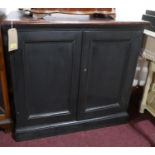 An early 20th century black painted pine side cabinet, with mahogany top, raised on stepped base,