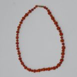 An antique coral necklace composed of 63 coral beads of alternating small and larger size