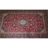 A Persian Kahsan carpet, central double pendent medallion with repeating spandrels on a rouge field,