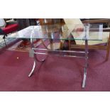A rectangular glass low table, on chrome support and stretched X-frame