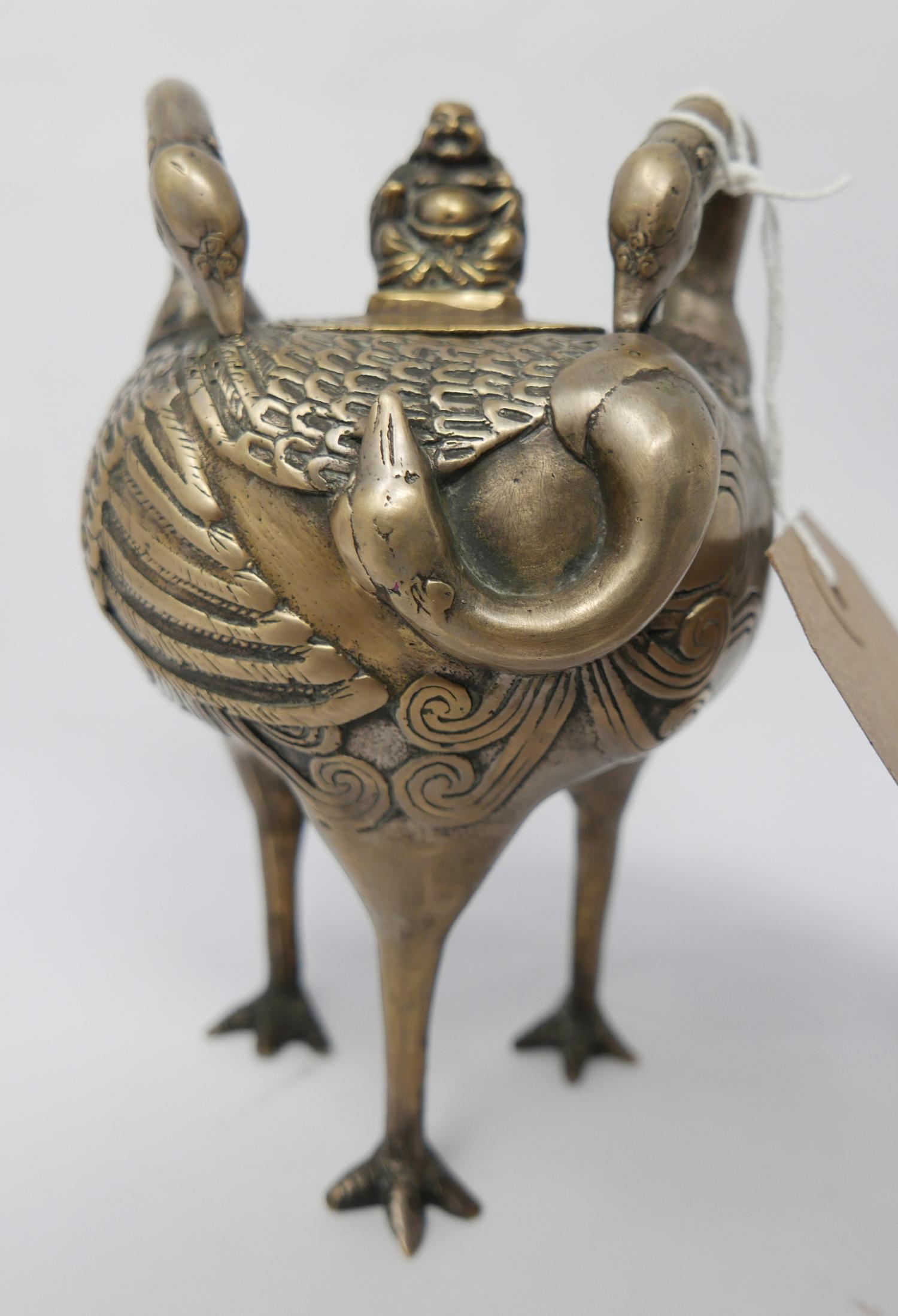 A Chinese bronzed lidded pot of stylised crane design standing on three tall bird's feet and the lid