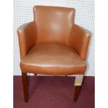 A tub style tan faux leather and brass studded desk chair