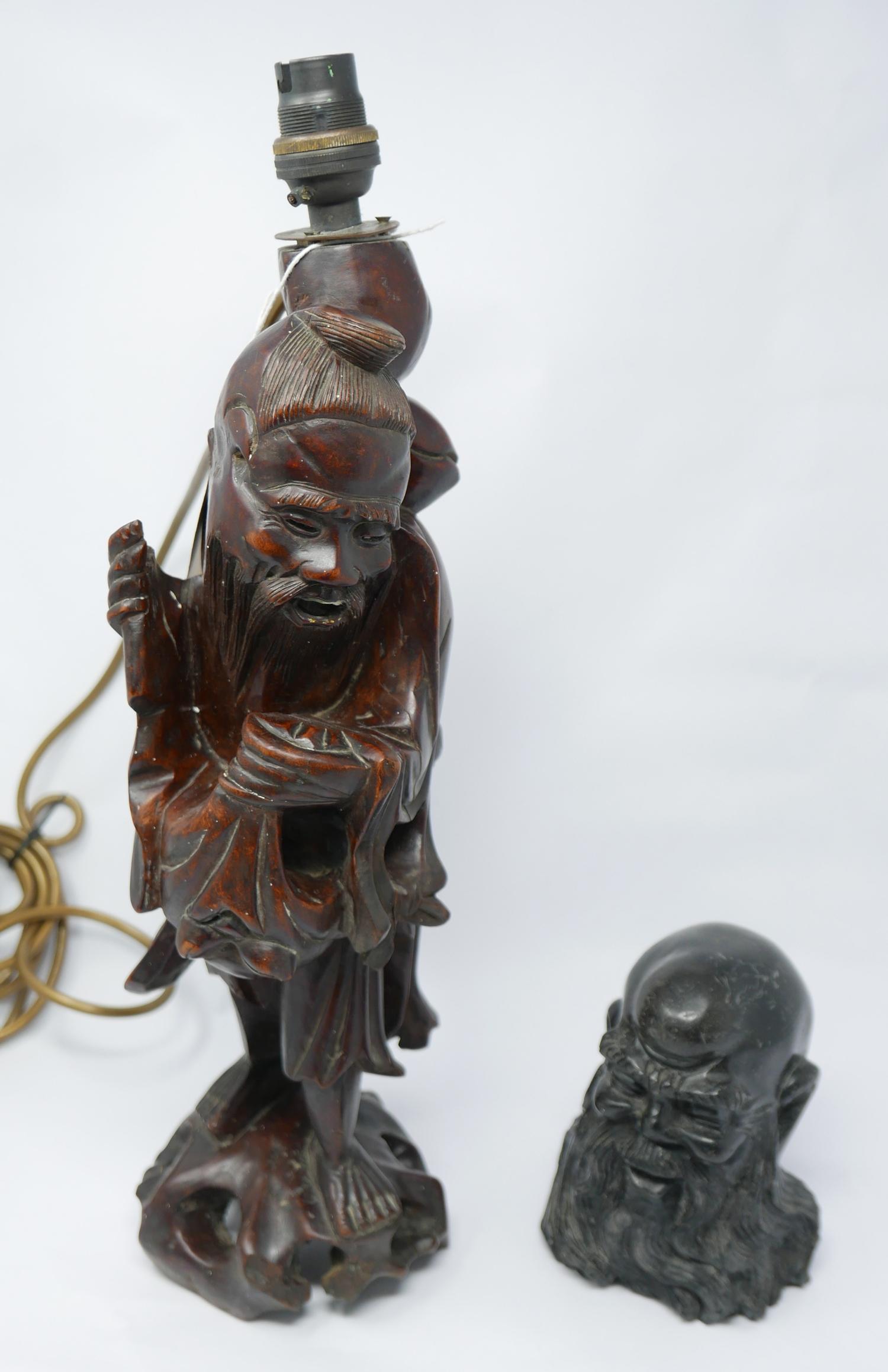 A Chinese carved hardwood lamp in the form of a robed sage standing on a craggy base, 40 x 10cm, and