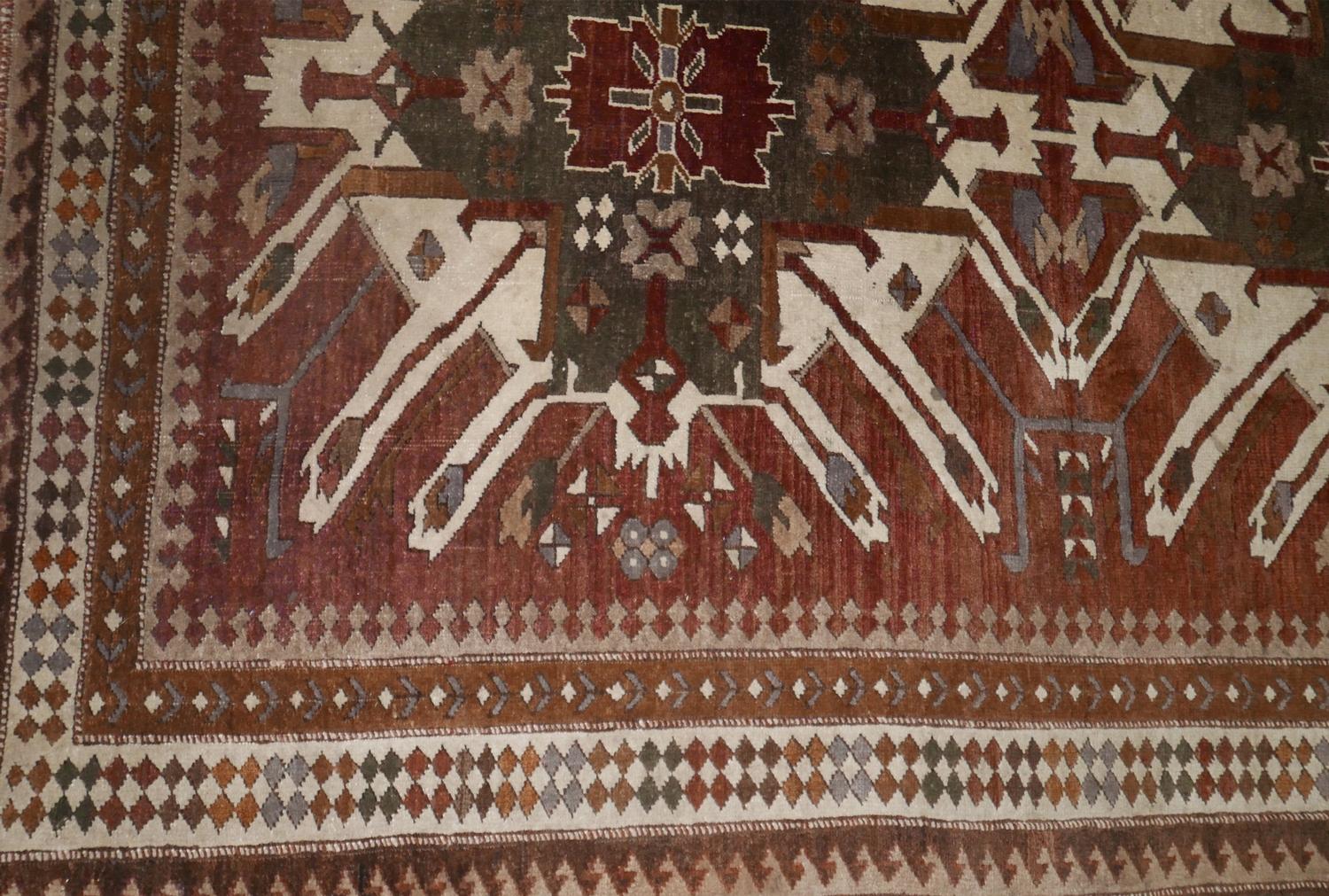 A 20th century north west Persian rug with two large geometric medallions, on a green and maroon - Image 2 of 3