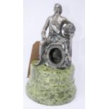 A silver plated pocket watch stand in the form of a seated gentleman, raised on stepped circular