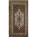 A 20th century Turkish rug with geometric design on a cream and brown ground, 205 x 114cm