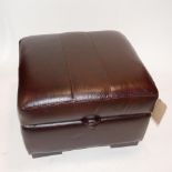 A contemporary faux leather ottoman footstool