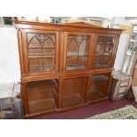 An early 19th century Gothic revival oak bookcase, with three glazed doors above open shelves,