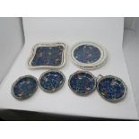 A collection of Royal Doulton plates and dishes, decorated to center with parrots amongst flowers on