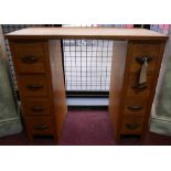 A petite mid century oak desk fitted with twin pedestals, marked 'Harrison's', H.76 W.85 D.44