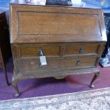 An early 20th century oak bureau, the fall front with fully fitted interior and glass inkwells,