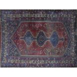 An antique Qashqai carpet with triple pole diamond medallion, within a lozenge field, on a red and