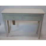 A contemporary white paint side table, with two drawers, raised on turned legs, H.74 W.92 D.32cm