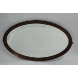 An early 20th century mahogany oval mirror with beveled plate, 63 x 101cm