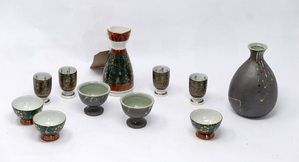 Two Japanese sake jars and a collection of sake cups