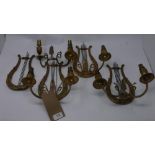 A set of four lyre shaped gilt metal two light wall sconces, H.27 W.23cm