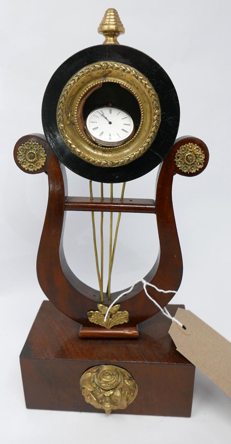 A mahogany and brass mounted harp shaped watch stand, on rectangular block base, with brass floral