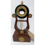A mahogany and brass mounted harp shaped watch stand, on rectangular block base, with brass floral