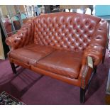 A 'Pegasus' Chesterfield style sofa with tan leather button back upholstery, raised on reeded