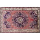 A North West Persian Tafresh rug, central medallion with repeating petal motifs on a rouge field,