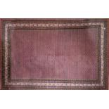 An Indo Heriz carpet with repeating floral motifs, on a salmon pink ground, contained by many