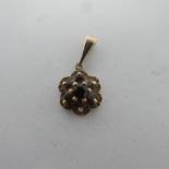 A 9ct yellow gold pendant of floral design with garnet to centre, marked 375