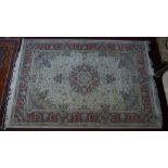 A Persian Tabriz style rug, central floral medallion on a cream ground within stylised floral